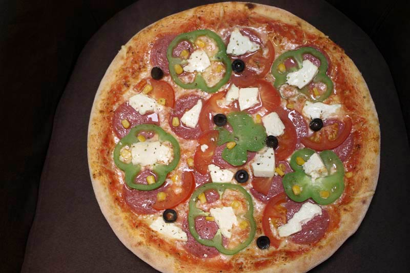 Pizza mit Paprika, Tomaten und Salami